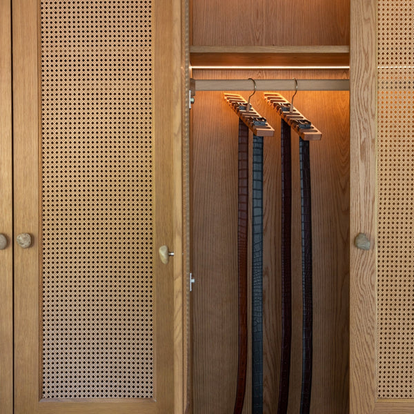 Wooden wardrobe with hangers and belts inside