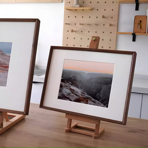 Framed landscape photo on a wooden stand with a pegboard in the background. Black walnut beveled picture frame. 