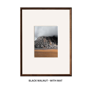 Framed artwork with a black walnut frame and white mat on a white background. Black walnut beveled frame with mat. 