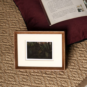 Framed photograph on a textured surface with a book in the background