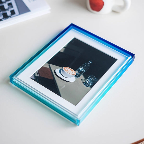 Ombre photo frame with blue border on a white surface