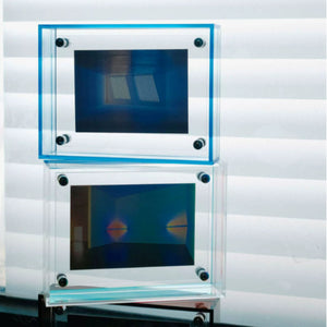 Two stacked acrylic picture frame with reflective surfaces on a white background