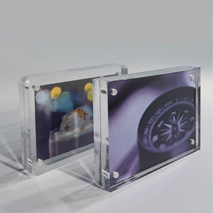 Two clear acrylic picture frames with printed designs on a gray background