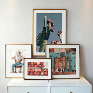 Collection of framed photographs on a white surface with a light gray wall background
