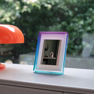 Colorful ombre acrylic photo frame on a surface with a blurred outdoor background