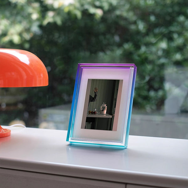 Colorful ombre acrylic photo frame on a surface with a blurred outdoor background