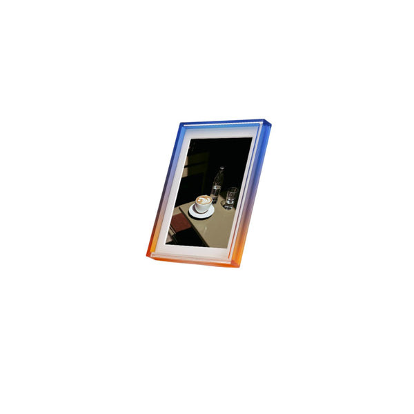 Ombre colour blue and green photo frame with a reflection of a table setting on a white background