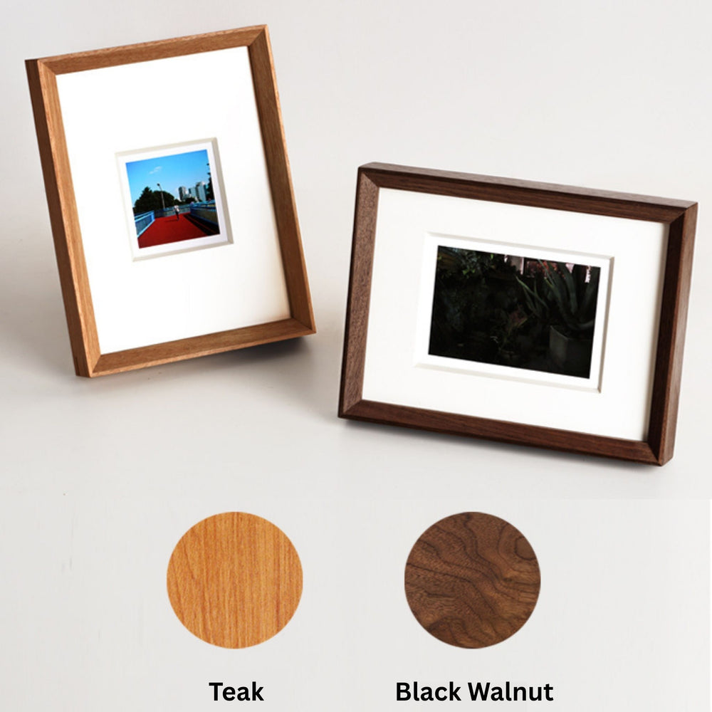 Framed photograph of a child in winter clothing with a blurred background. Black walnut beveled frame white background. 