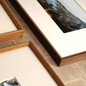Wooden picture frames on a textured surface with a small photograph inside one frame.