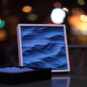 Thin white art frame with blue wave-patterned light box with blurred lights in the background