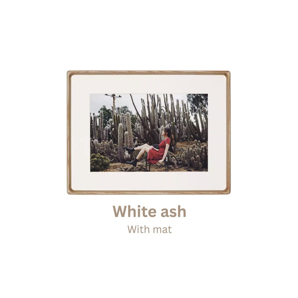 White ash wood-framed photograph of a person in a red dress sitting among cacti with 'White ash' frame text.